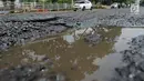 Kondisi jalan berlubang yang masih tergenang air di ruas Jalan Lapangan Ros, Tebet, Jakarta, Sabtu (11/5/2019). Jalan-jalan berlubang yang terisi air tersebut dapat mengakibatkan kecelakaan bagi pengendara kendaraan bermotor. (merdeka.com/Imam Buhori)
