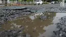Kondisi jalan berlubang yang masih tergenang air di ruas Jalan Lapangan Ros, Tebet, Jakarta, Sabtu (11/5/2019). Jalan-jalan berlubang yang terisi air tersebut dapat mengakibatkan kecelakaan bagi pengendara kendaraan bermotor. (merdeka.com/Imam Buhori)