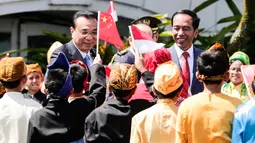 Presiden Jokowi bersama PM China Li Keqiang menyapa anak-anak berbaju daerah saat penyambutan kenegaraan di Istana Bogor, Senin (7/5). Kerja sama perdagangan dan investasi merupakan isu utama yang akan dibahas Li dan Jokowi. (Mast Irham/Pool via AP)
