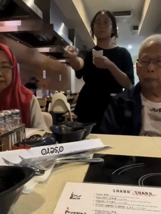 Menjadi pekerja part time di restoran, Cinta mengenakan kaos hitam oversize yang serasi dengan bawahannya. [Istimewa]