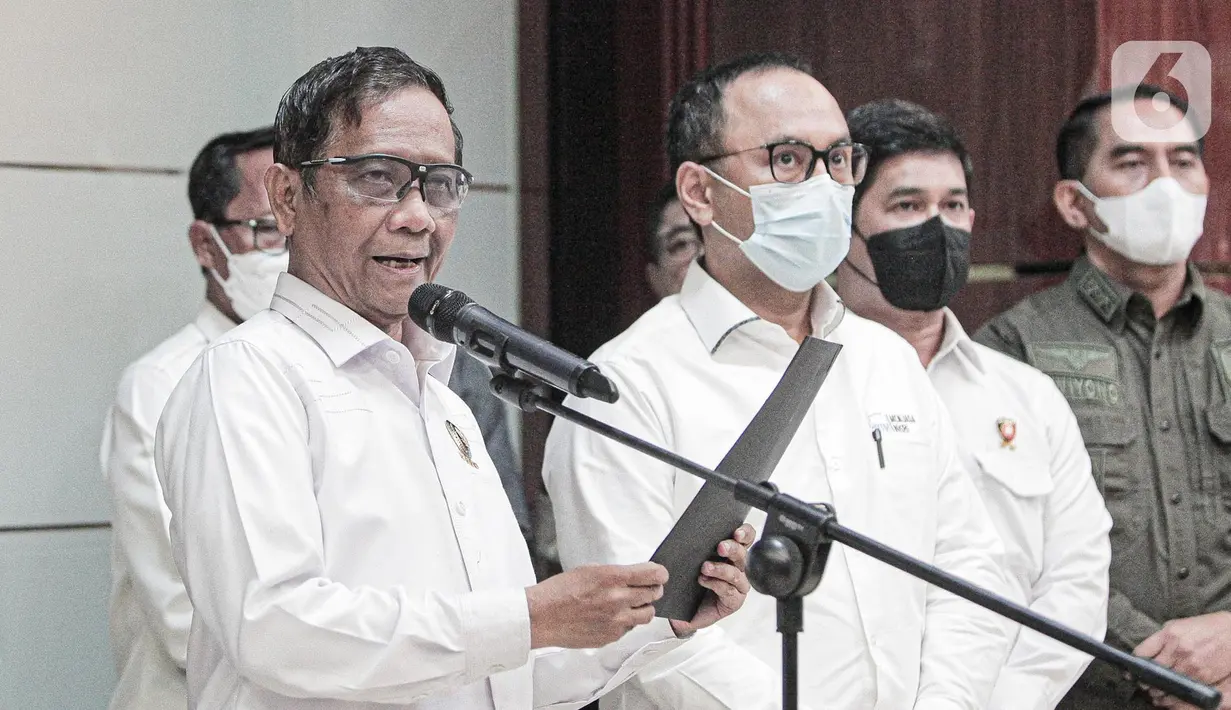 Menko Polhukam Mahfud MD (tengah) didampingi Kepala PPATK Ivan Yustiavandana menyampaikan keterangan terkait situasi Papua usai penetapan Gubernur Papua Lukas Enembe sebagai tersangka kasus korupsi di Gedung Kemenko Polhukam, Jakarta, Senin (19/9/2022). Menurut Mahfud MD, situasi di Papua memanas. (Liputan6.com/Faizal Fanani)