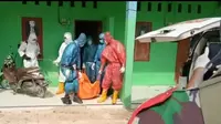 Penanganan jenazah pasien meninggal dengan status PDP di Sultra, memakai jas hujan karena kekurangan APD.(Liputan6.com/Ahmad Akbar Fua)