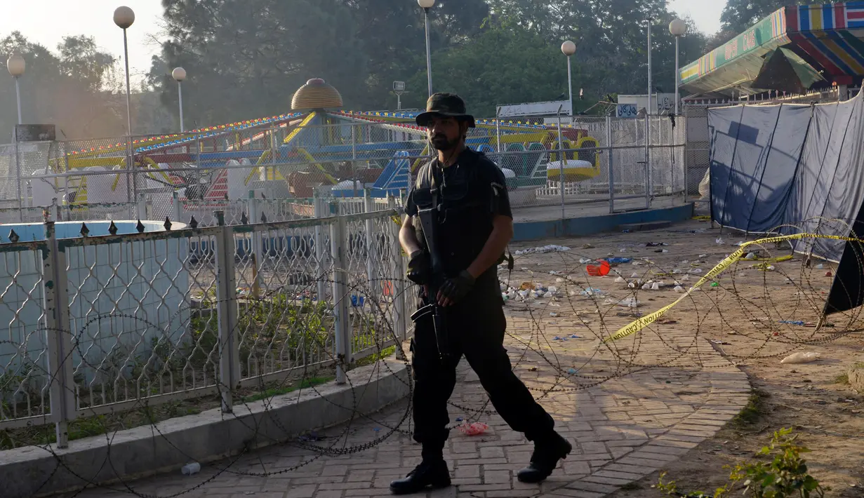 Petugas polisi Pakistan berjaga di lokasi bom bunuh diri di taman Gulshan e Iqbal Park di Lahore, Pakistan, Senin (28/3). Korban tewas akibat ledakan bom tersebut mencapai sekitar 69 orang. (AFP/ARIF ALI)