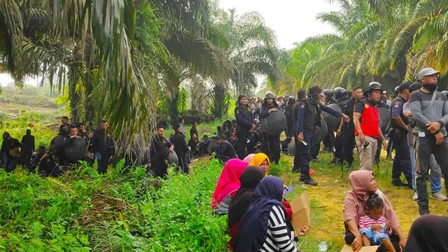 Polisi dan petugas keamanan PT Nusa Wahana Raya menghadang warga yang berusaha masuk ke eksekusi lahan di Kabupaten Pelalawan.