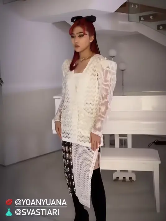 Isyana Sarasvati tampil dengan atasan brokat dipadukan slit skirt putih hitam dipadukan knee boots hitam. [@isyanasarasvati]