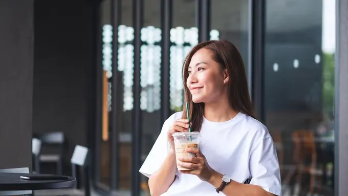 Seorang perempuan memegang kopi (Foto Dok: Freepik/farknot)