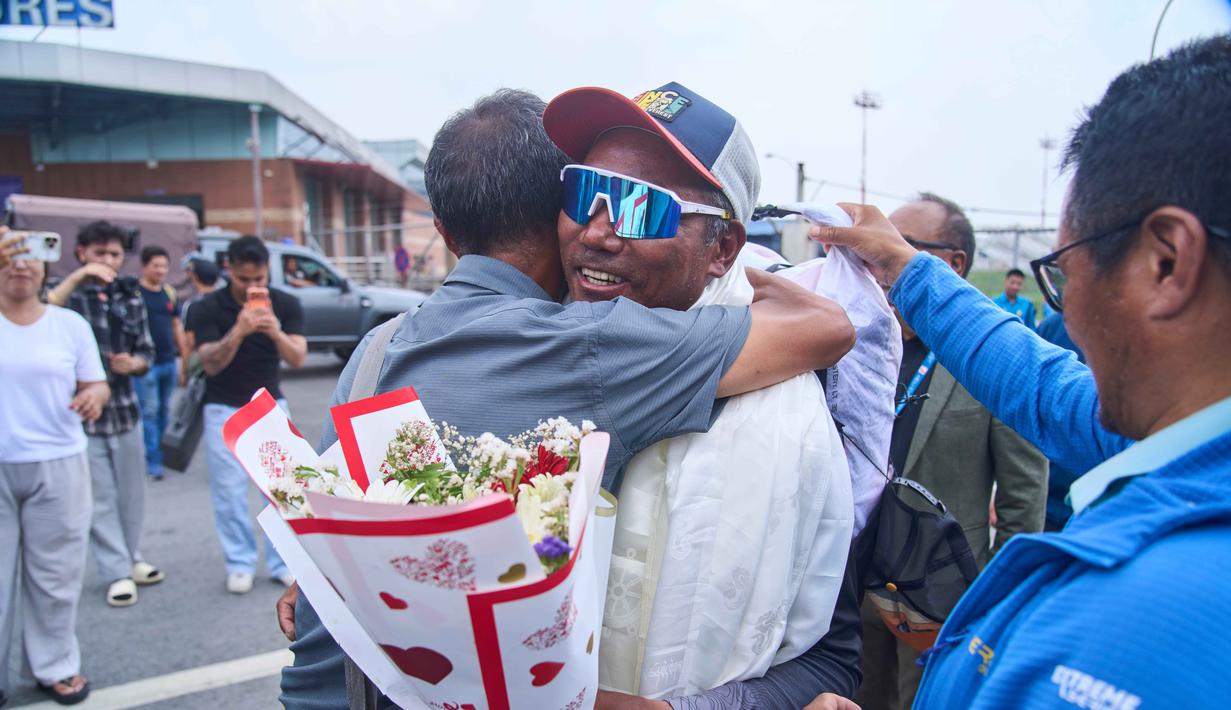 Pemandu gunung legendaris asal Nepal, Kami Rita Sherpa (tengah kanan) saat kembali dari Gunung Everest setelah pendakiannya yang ke-32, disambut dengan selendang dan bunga saat tiba di bandara, Kathmandu, Jumat 22 Mei 2026. (AP Photo/Niranjan Shrestha)