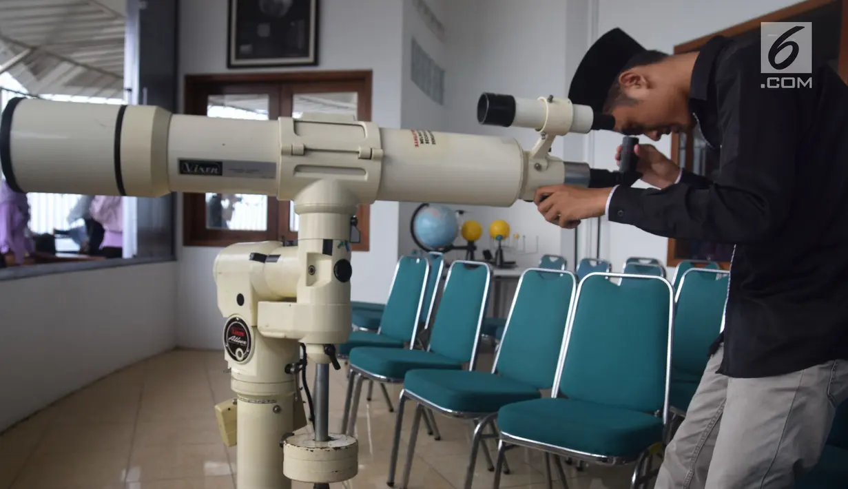 Seorang anggota tim Rukyat Hilal AL Husna MAJT Semarang mengintip hilal di Menara Al-Husna Masjid Agung Jawa Tengah, Selasa (15/5 ). (Liputan6.com/Gholib)