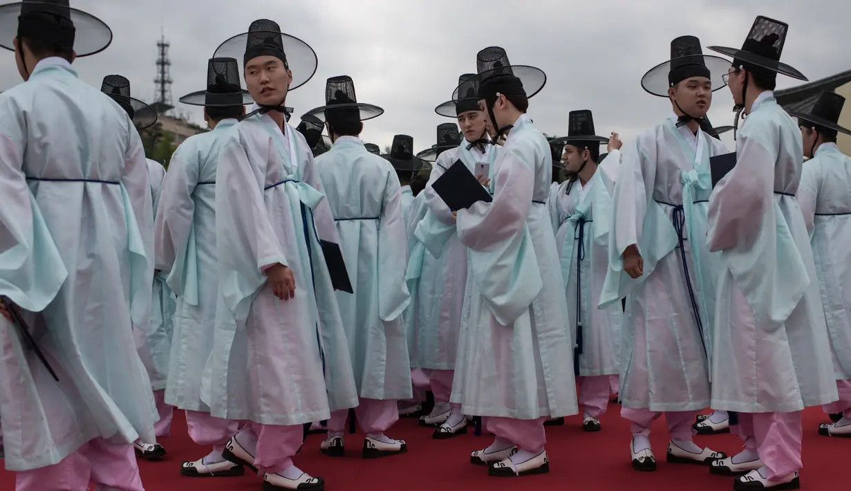 Pelajar berkostum tradisional Korsel menghadiri upacara Coming of Age Day (Hari Kedewasaan) di Namsan Hanok Village, Seoul, Senin (15/5). Di usia 20, mereka diperbolehkan merokok, mengonsumsi minuman beralkohol dan mengikuti pemilihan umum. (Ed JONES/AFP)