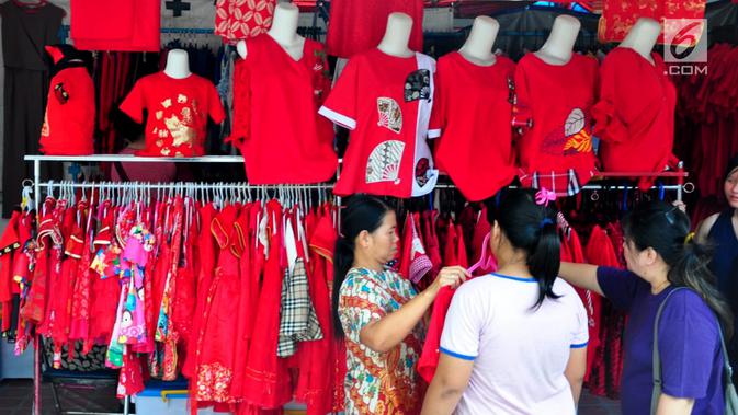 Warga membeli baju di Pasar Imlek Semawis 2570, kawasan Pecinan Semarang, Jawa Tengah, Sabtu (2/1). Pada tahun Babi Tanah ini Pasar Semawis mengusung tema 'Warga Rukun Agawe Santoso'. (Liputan6.com/Gholib)