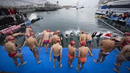 Sejumlah peserta melompat ke dalam air dalam ajang Copa Nadal yang berlangsung di Barcelona's Port Vell, Barcelona, Kamis (25/12/2025) waktu setempat. Acara tersebut diikuti lebih dari 450 peserta. (AFP/Josep Lago)