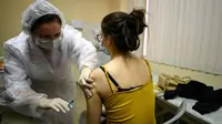 Perawat menyuntikkan vaksin corona Sputnik V di tengah pandemi yang sedang berlangsung di sebuah klinik di Moskow, Sabtu (5/12/2020). Presiden Rusia Vladimir Putin memerintahkan pihak berwenang memulai vaksinasi massal untuk orang-orang berisiko tinggi tertular Covid-19. (Kirill KUDRYAVTSEV/AFP)
