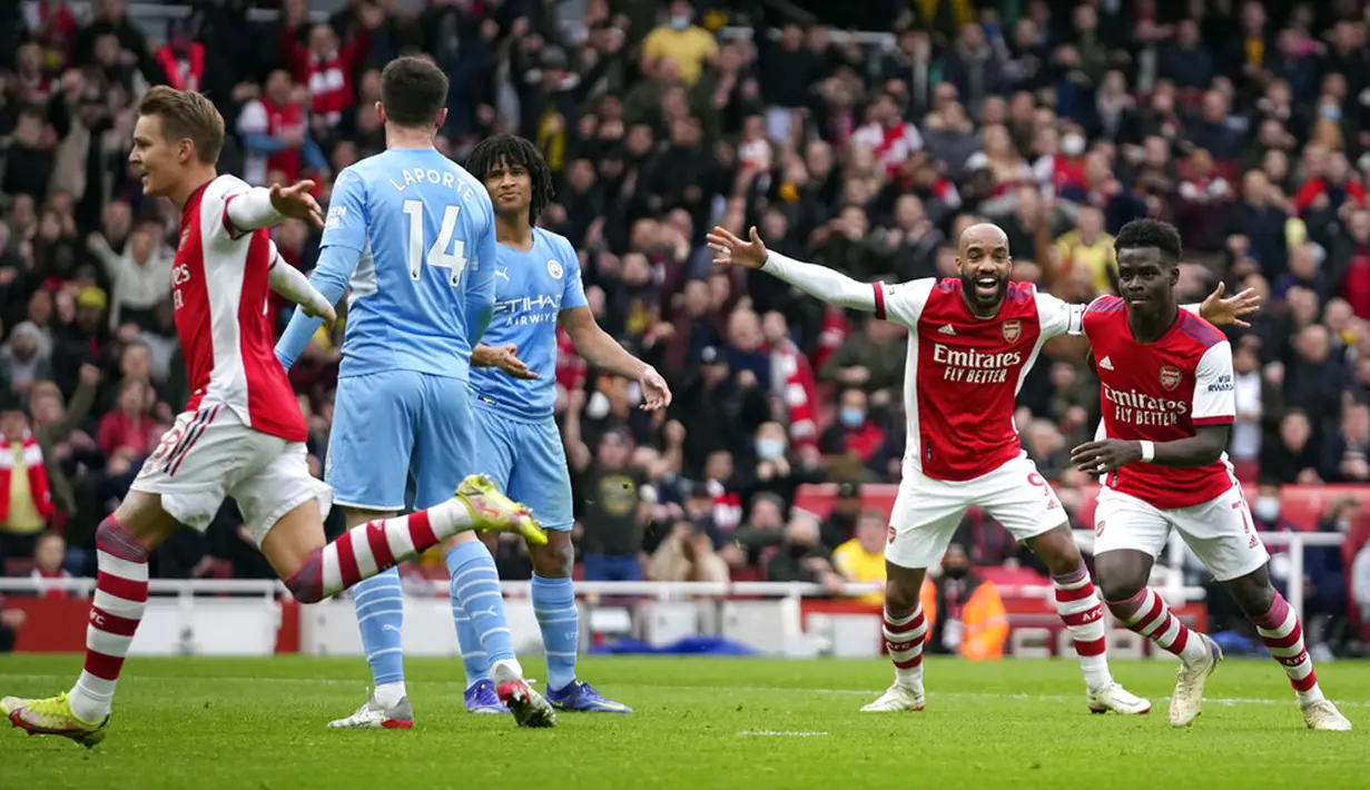 Pemain Arsenal Bukayo Saka (kanan) merayakan dengan rekan setimnya setelah mencetak gol ke gawang Manchester City pada pertandingan sepak bola Liga Inggris di Stadion Emirates, London, Inggris, 1 Januari 2022. Manchester City menang 2-1. (AP Photo/Matt Dunham)