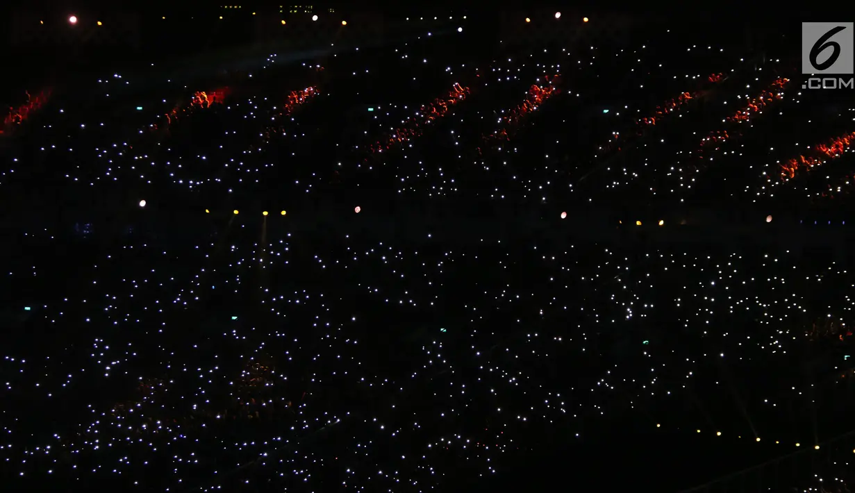 Ribuan penonton menyalakan flash ligt di ponselnya masing-masing saat malam penutupan Asian Games 2018 di Stadion GBK, Jakarta, Minggu (9/2). Hal ini menjadi unik dan menambah syahdu malam penutupan Asian Games 2018. (Liputan6.com/Helmi Fithriansyah)