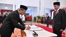 Wakil Ketua KPK periode 2019-2023 Alexander Marwata (kiri) menandatangani nota pelantikan disaksikan Presiden Joko Widodo di Istana Negara, Jakarta, Jumat (20/12/2019). Upacara pelantikan lima pimpinan KPK periode 2019-2023 dipimpin langsung Presiden Joko Widodo. (Foto: Biro Pers Setpres)