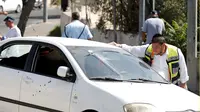 Aksi Penembakan ala Koboi di Yerusalem, 8 Orang Terluka. Petugas kesehatan melihat kondisi mobil dengan banyak lubang peluru (Reuters)