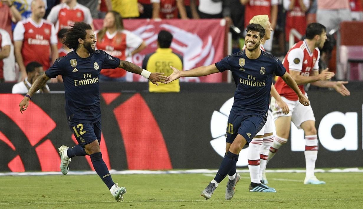 Gelandang Real Madrid, Marco Asensio (kanan) berselebrasi dengan rekannya Marceloa usai mencetak gol ke gawang Arsenal selama pertandingan International Champions Cup (ICC) 2019 di FedExField, Landover, Maryland (24/7/2019). Madrid menang adu penalti atas Arsenal 3-2 (2-2). (AP Photo/Nick Wass)