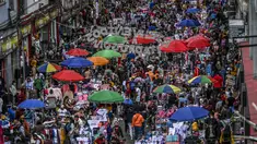 Orang-orang berbelanja hadiah Natal di jalan komersial di San Victorino, Bogota, Kolombia, Senin (21/12/2020). Kota-kota utama di Kolombia pada Senin mengumumkan pembatasan yang mempengaruhi sekitar 15 juta orang karena peningkatan penularan covid-19 menjelang Natal. (Juan BARRETO/AFP)