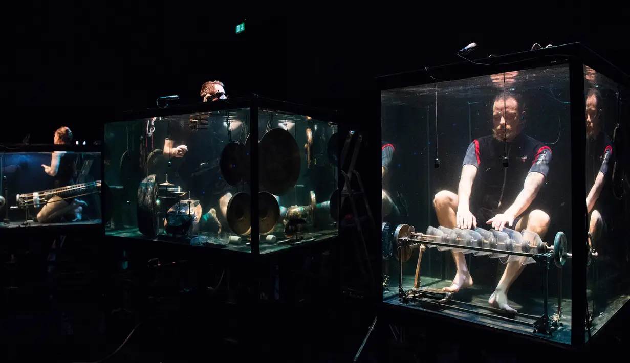 Konser Underwater AquaSonic menghadirkan lima pemain yang menenggelamkan diri mereka di tangki air kaca untuk memainkan instrumen buatan sendiri dan bernyanyi sepenuhnya di bawah air di Aarhus, Denmark, Rabu (19/4). (AFP PHOTO / Jonathan NACKSTRAND)