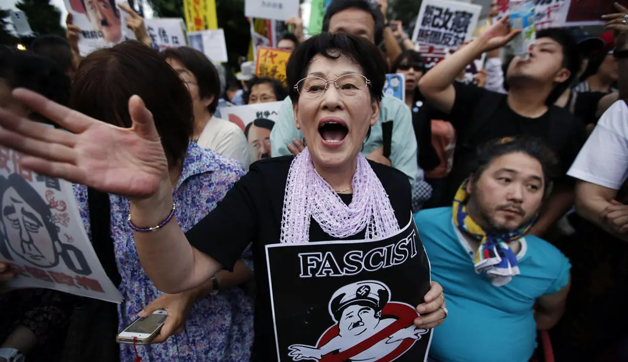 Dalam aksinya, para demonstran membawa plakat yang menuding kebijakan PM Jepang, Shinzo Abe, yang ingin memperluas peran militer sebagai bentuk fasisme, (30/6/2014). (REUTERS/Issei Kato)