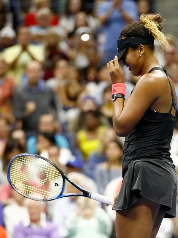 Petenis Jepang, Naomi Osaka bereaksi setelah mengalahkan Serena Williams pada partai final AS Terbuka di New York, Sabtu (8/9). Osaka mencatatkan sejarah dengan menjadi orang Jepang pertama yang memenangi gelar grand slam. (JULIAN FINNEY/GETTY IMAGES/AFP)