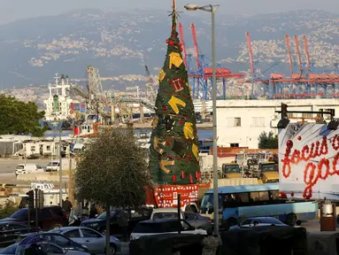 Pakaian dan peralatan milik petugas pemadam kebakaran yang tewas dalam ledakan di Pelabuhan Beirut diletakkan pada sebuah pohon Natal di Beirut, Lebanon (20/12/2020). Pohon Natal ini didirikan pada Minggu (20/12) di dekat Pelabuhan Beirut. (Xinhua/Bilal Jawich)