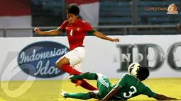 Bayu Gatra (4) melompat menghindari tackling keras pemain belakang Maladewa Mohamed Samdhooh (Liputan6.com/Helmi Fithriansyah) 
