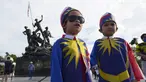 Dua anak laki-laki yang mengenakan kostum bendera nasional Malaysia berfoto di depan Monumen Nasional saat perayaan Hari Nasional ke-64 untuk memperingati kemerdekaan dari penjajahan Inggris di Kuala Lumpur, Malaysia, Selasa (31/8/2021). (AP Photo/Vincent Thian)