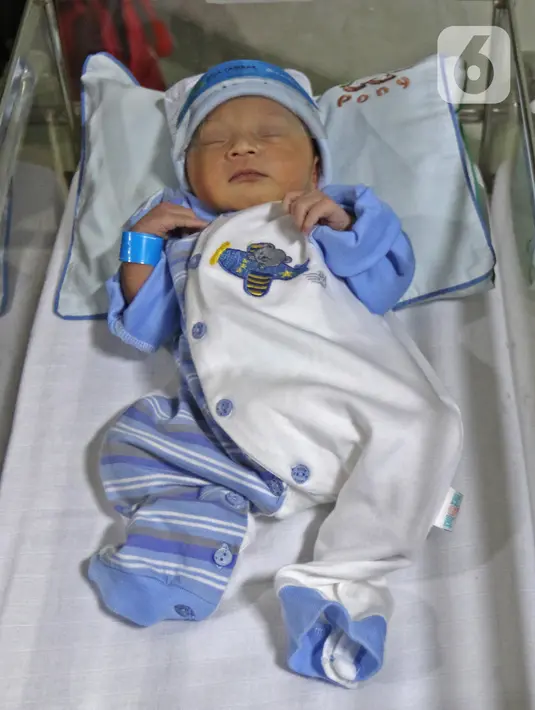 Seorang bayi memakai face shield atau pelindung wajah di Rumah Sakit Ibu dan Anak Tambak, Jakarta, Selasa (14/4/2020). RSIA Tambak sejak 12 April 2020 membuat kebijakan bayi yang baru lahir dipakaikan pelindung wajah untuk mencegah terpapar virus corona COVID-19. (Liputan6.com/Herman Zakharia)