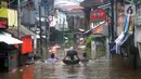 Warga menyusuri banjir yang merendam kawasan Karet Pasar Baru Barat, Jakarta, Selasa (25/2/2020). Banjir yang terjadi sejak subuh akibat luapan Kanal Banjir Barat tersebut merendam ratusan rumah hingga setinggi dua meter. (merdeka.com/Arie Basuki)