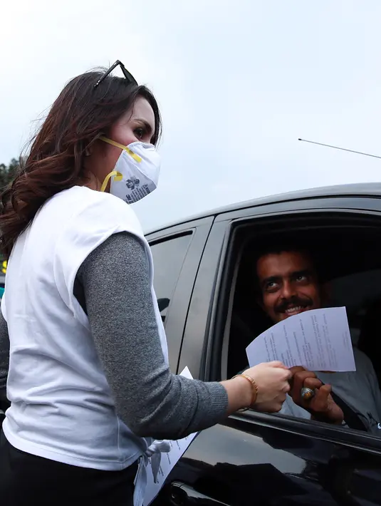 Dalam kesempatan itu, mereka membagi-bagikan lembaran berisi seruan terhadap masyarakat untuk melawan asap. (Deki Prayoga/Bintang.com)