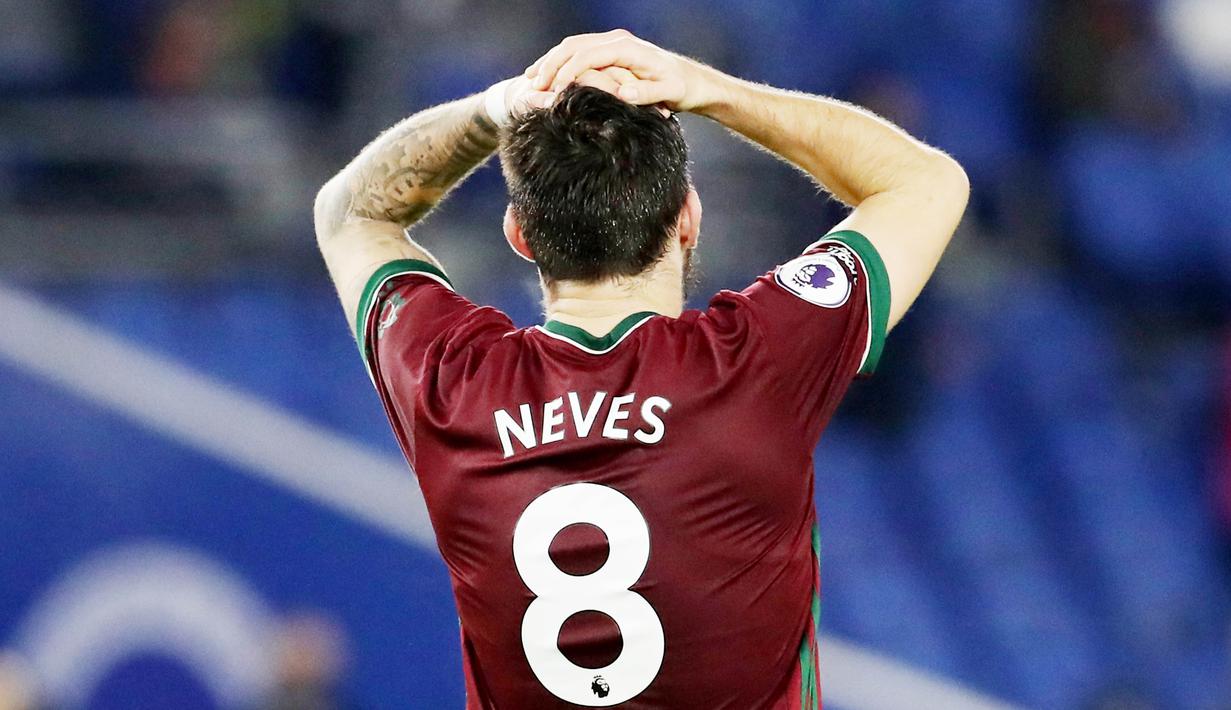 Pemain Wolverhampton Wanderers, Ruben Neves, memegang kepalanya saat melawan Brighton and Hove Albion pada laga Liga Inggris di Stadion Amex, Sabtu (2/1/2021). Kedua tim bermain imbang 3-3. (Gareth Fuller/POOL/AFP)