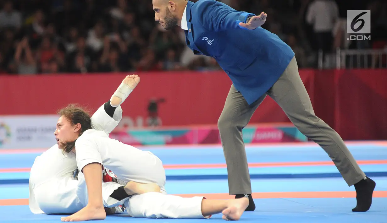 Atlet Jujitsu putri Indonesia Simone Julia mengunci Tsogkhuu Udval dari Mongolia saat bertanding pada nomor final putri 62 kg Asian Games 2018, Jakarta, Sabtu (25/8). Simone gagal mempersembahkan medali perunggu. (Merdeka.com/Arie Basuki)