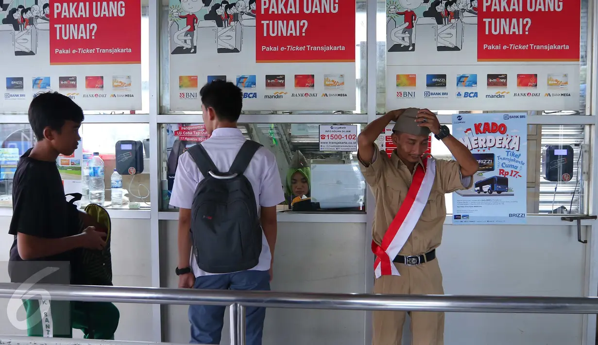 Penumpang saat membeli tiket di Halte Trans Jakarta, Selasa (16/8).Petugas mengenakan pakaian tentara perjuangan tempo dulu untuk menyambut para penumpang. (Liputan6.com/Angga Yuniar)
