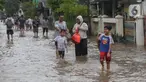 Warga melintasi genangan air di Perumahan Ciledug Indah 1, Kota Tangerang, Banten, Selasa (4/3/2025). (Liputan6.com/Angga Yuniar)
