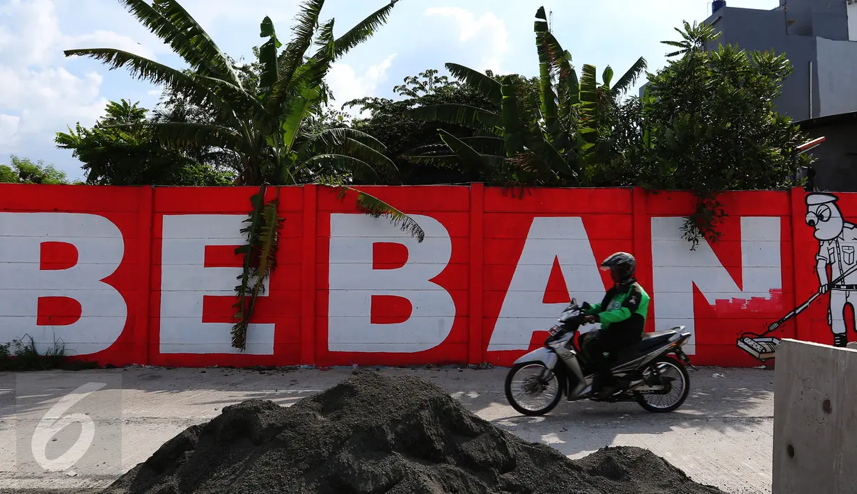 Pengendara motor melintasi mural bernuansa politik di Penjaringan, Jakarta, Minggu (7/8). Pesan-pesan yang disampaikan oleh mural politik ini biasanya bercermin dari kegiatan politik di Indonesia saat ini. (Liputan6.com/Angga Yuniar)