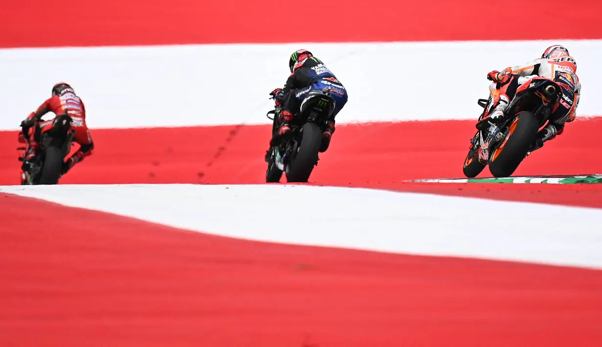 Di posisi kedua, Francesco Bagnaia membalap dengan heroik pada tiga lap terakhir untuk menyusul beberapa rider di depannya setelah berganti motor. Podium MotoGP Austria dilengkapi oleh pembalap Pramac Racing, Jorge Martin. (Foto: AFP/Joe Klamar)