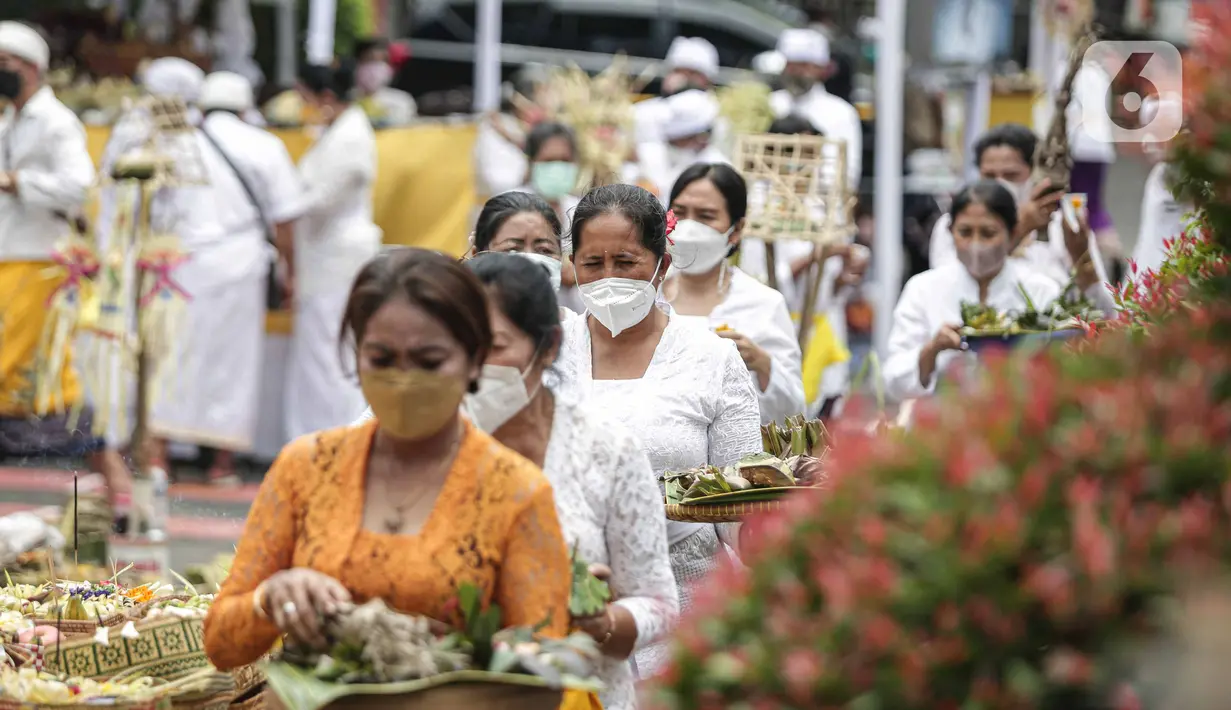 Umat Hindu membawa sesaji saat mengikuti upacara Tawur Agung Kesanga di Pura Amerta Jati, Cinere, Depok, Rabu (2/3/2022).  Upacara Tawur Agung Kesanga itu sebagai penyucian diri guna memperingati Hari Raya Nyepi Tahun Baru Saka 1944. (Liputan6.com/Faizal Fanani)