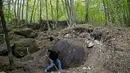 Suad Keserovic menggali tanah di sekitar bola batu temuannya di hutan Desa Podunavlje, Bosnia dan Herzegovina, Senin (11/4). Pria itu mengklaim bola batu berdiameter 3,30 meter tersebut memiliki berat sekitar 35 ton. (REUTERS/Dado Ruvic)