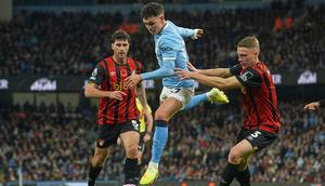 Phil Foden (Manchester City) berebut bola dengan Adrien Truffert dan Marcos Senesi (Bournemouth) dalam laga Liga Inggris di Etihad Stadium, 2 November 2025. (AP Photo/Ian Hodgson)