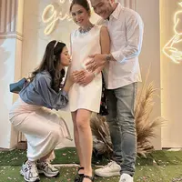 Sang suami mengenakan kemeja putih panjang, dipadukan celana denim dan sneakers putihnya. [@furrycitra]