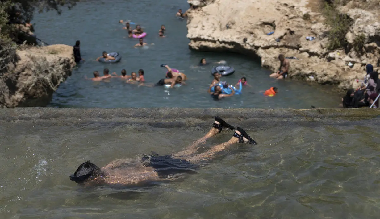 <p>Seorang anak laki-laki menyelam di air selama saat Idul Adha di Taman Nasional Gan HaShlosha. (AP Photo/Ohad Zwigenberg)</p>