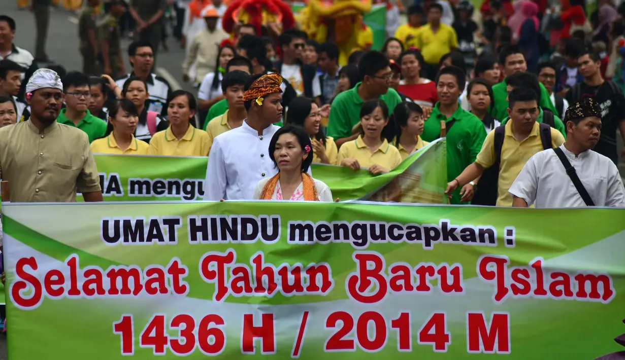 Sejumlah umat Hindu dan Buddha Jambi membentangkan spanduk ucapan selamat saat mengikuti Pawai Tahun Baru Islam 1436 H di Jalan Sultan Agung, Jambi, Jumat (24/10/2014). (Antara Foto/Wahdi Septiawan)