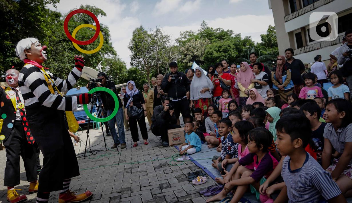 Badut yang tergabung dalam komunitas Aku Badut Indonesia (ABI) menghibur anak-anak di pengungsian korban banjir di Gor Pangadegan, Jakarta, Selasa (7/1/2020). Trauma healing diberikan para badut sebagai bentuk kepedulian terhadap anak-anak korban banjir Jakarta. (Liputan6.com/Faizal Fanani)