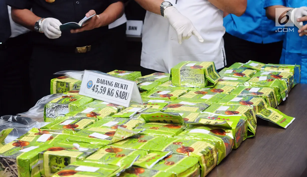 Petugas BNN dan Bea Cukai menunjukkan barang bukti 44 bungkus narkotika jenis sabu saat rilis di gedung BNN, Jakarta, Kamis (20/7). BNN menyita 44 bungkus sabu seberat 45,59 kg dari delapan orang tersangka. (Liputan6.com/Helmi Fithriansyah)