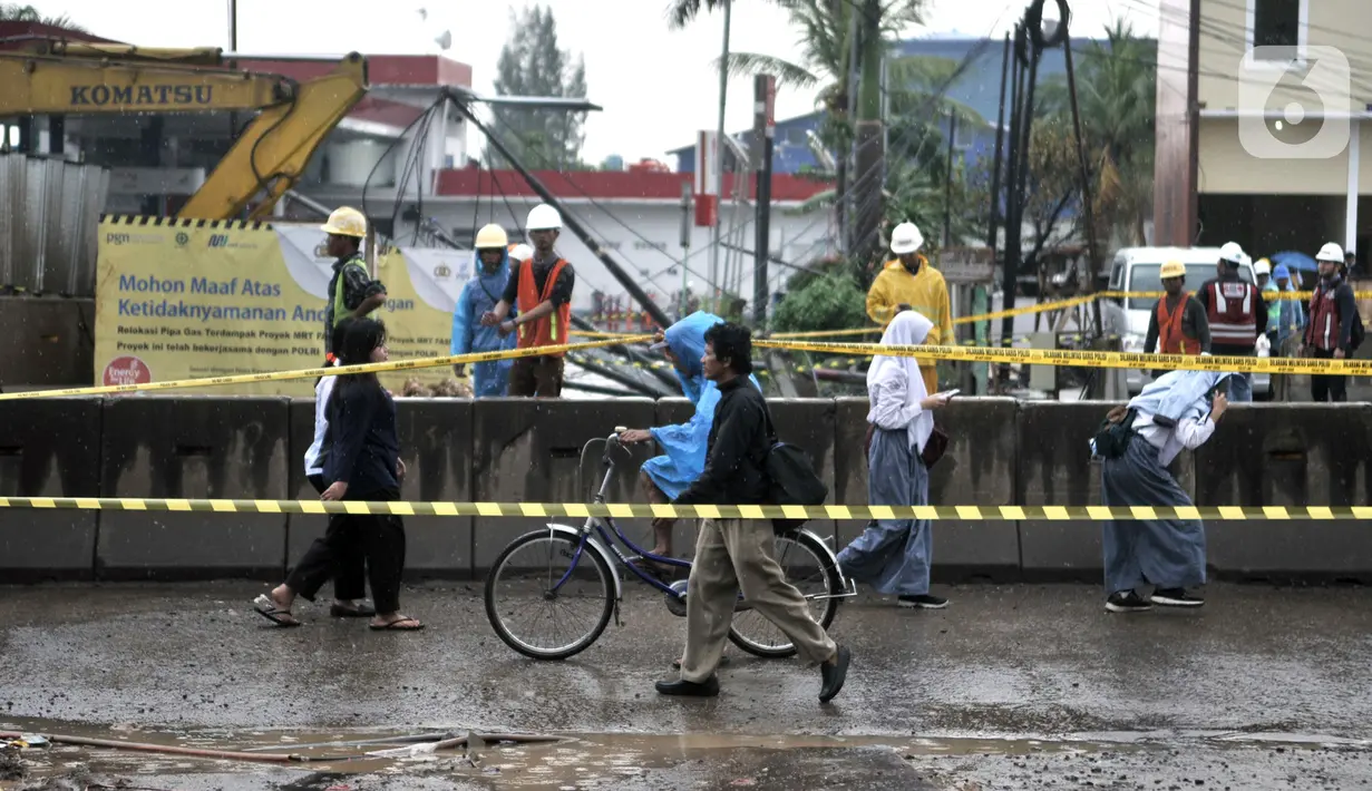 Warga melintasi lokasi semburan gas PGN di proyek Tol Dalam Kota rute Pulogebang-Kelapa Gading, Cakung, Jakarta, Kamis (12/3/2020). Semburan gas yang terjadi sekitar pukul 10.00 WIB tersebut akibat proyek penggalian mengenai pipa distribusi PGN. (merdeka.com/Iqbal Nugroho)