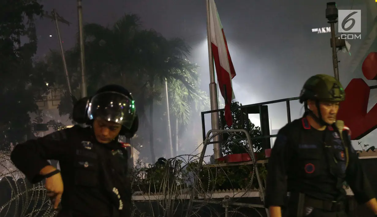 Bendera Merah Putih terbalik akibat kericuhan antara massa aksi dengan personil kepolisian yang berusaha menghalau massa yang berlaku anarkis di sekitar Gedung Bawaslu, Jalan MH Thamrin, Jakarta, Rabu (22/5/2019). Aksi unjuk rasa yang dimotori GNKR berakhir ricuh. (Liputan6.com/Helmi Fithriansyah)