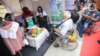 Penyandang disabilitas menjaga booth pada acara puncak peringatan Hari Disabilitas Internasional 2019 di Plaza Barat Gelora Bung Karno, Jakarta, Selasa (3/12/2019). Acara tersebut memamerkan produk UMKM dari puluhan organisasi penyandang disabilitas se-Indonesia. (Liputan6.com/Faizal Fanani)