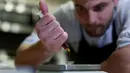 Chef Christopher Sayegh menimbang minyak THC (Tetrahydrocannabinol), dan CBD (Cannabidiol) yang akan digunakan sebagai campuran bahan masakan di sebuah restoran di Los Angeles, AS (29/4). (Reuters/ Mario Anzuoni)