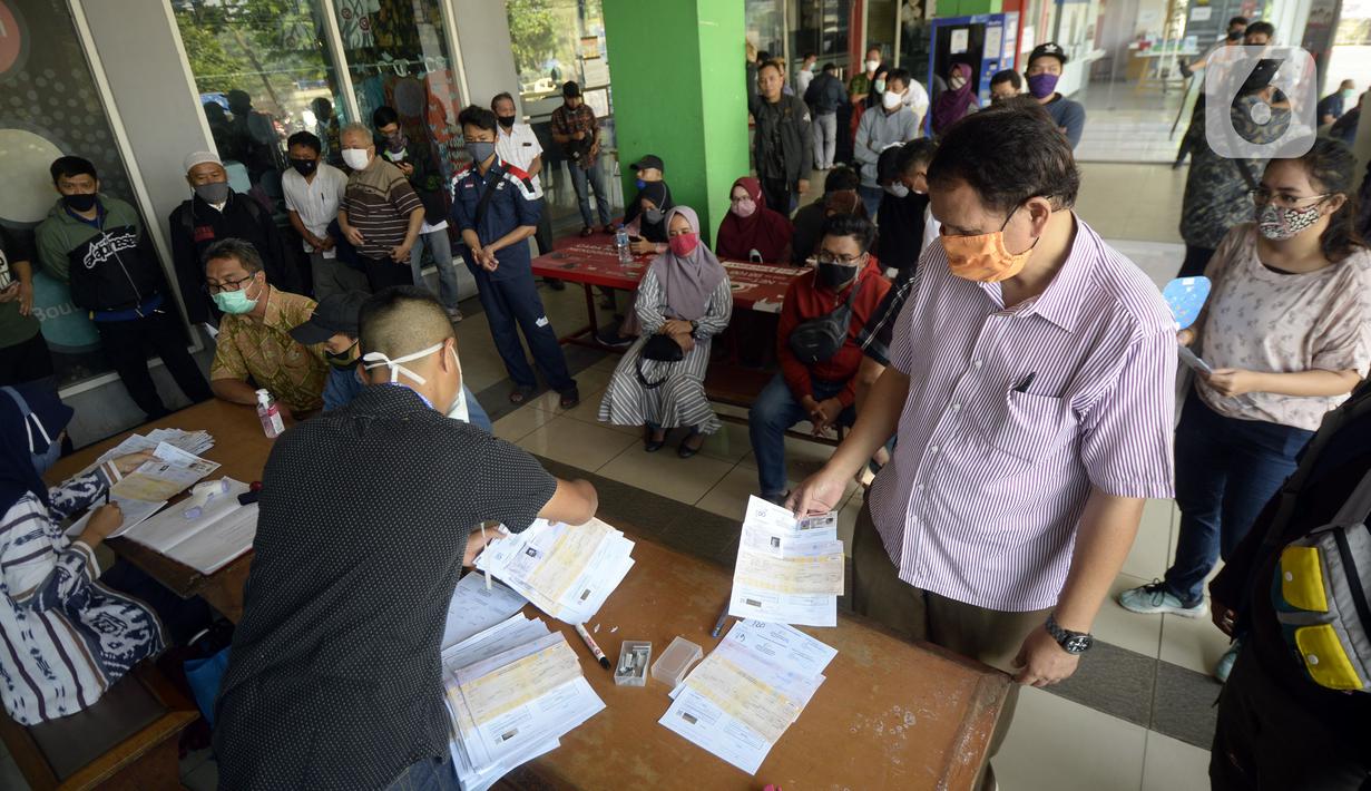 Warga antre saat mengurus SIM di Pelayanan SIM Keliling, Tangerang Selatan, Banten, Jumat (7/8/2020). Ditlantas Polda Metro Jaya memberi dispensasi bagi pemilik SIM yang masa berlakunya habis di masa pandemi COVID-19 bisa memperpanjang sampai akhir Agustus 2020. (merdeka.com/Dwi Narwoko)